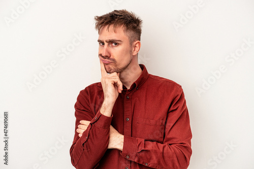Young caucasian man isolated on white background focused on a task, keeping forefingers pointing head. © Asier