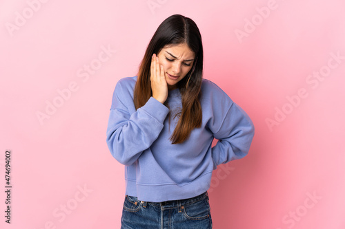 Young caucasian woman isolated on pink background with toothache