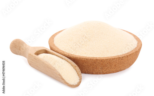 Semolina in wooden bowl and scoop on white background