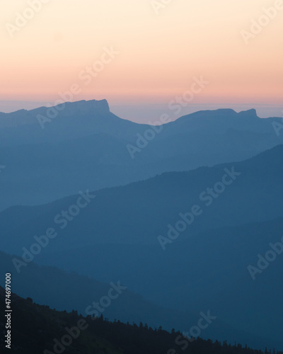 Mountain silhouette layers in the sunset light. Beautiful photography of the nature, blue layered background. Natural gradient.