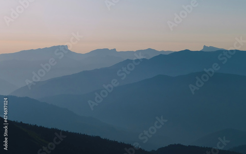 Mountain silhouette layers in the sunset light. Beautiful photography of the nature, blue layered background. Natural gradient.