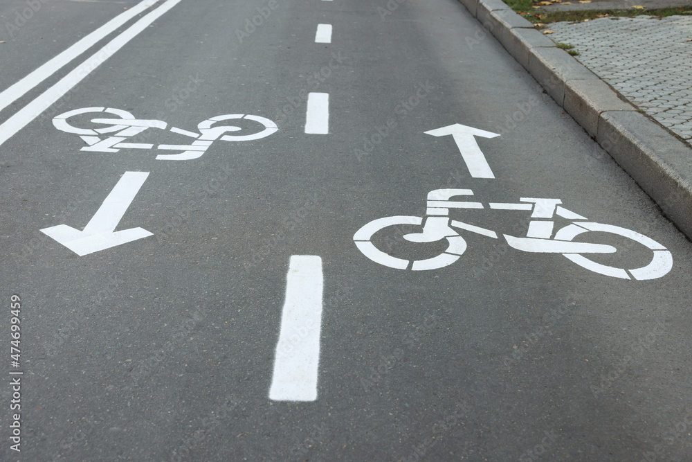 Two way bicycle lane with white signs on asphalt Two way bicycle lane with white signs on asphalt