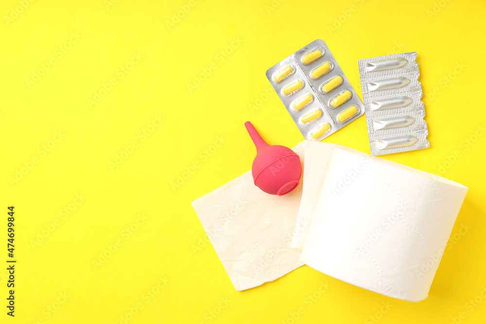 Concept of healthcare with hemorrhoids accessories on yellow background Concept of healthcare with hemorrhoids accessories on yellow background