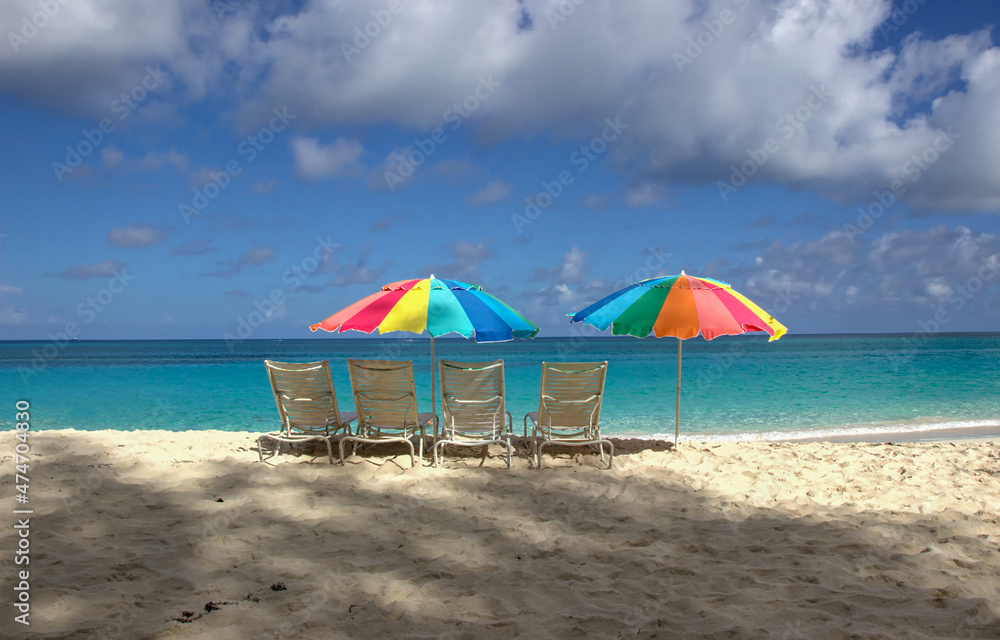 Beach chairs and colorful umbrellas on Paradise beach in Nassau, Bahamas Beach chairs and colorful umbrellas on Paradise beach in Nassau, Bahamas