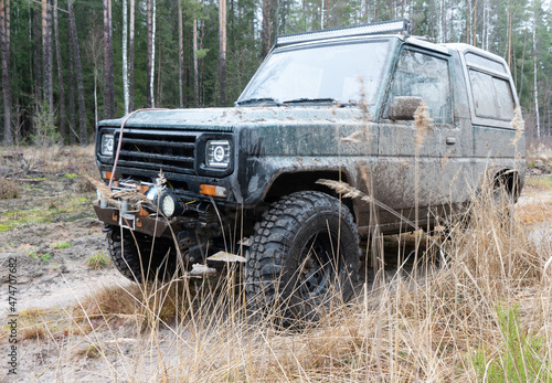 Photo of an off-road black car on muddy gravel road. Rally racing SUV. Automobile concept