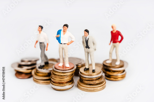 Miniature people successful businessmen stand on stacks of coins. Business and finance concept, professional growth