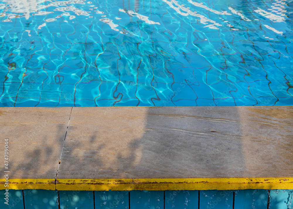 Obraz premium de focused frame on side of swimming pool and water blue surface of the water. Clean water runs down the edges of pool