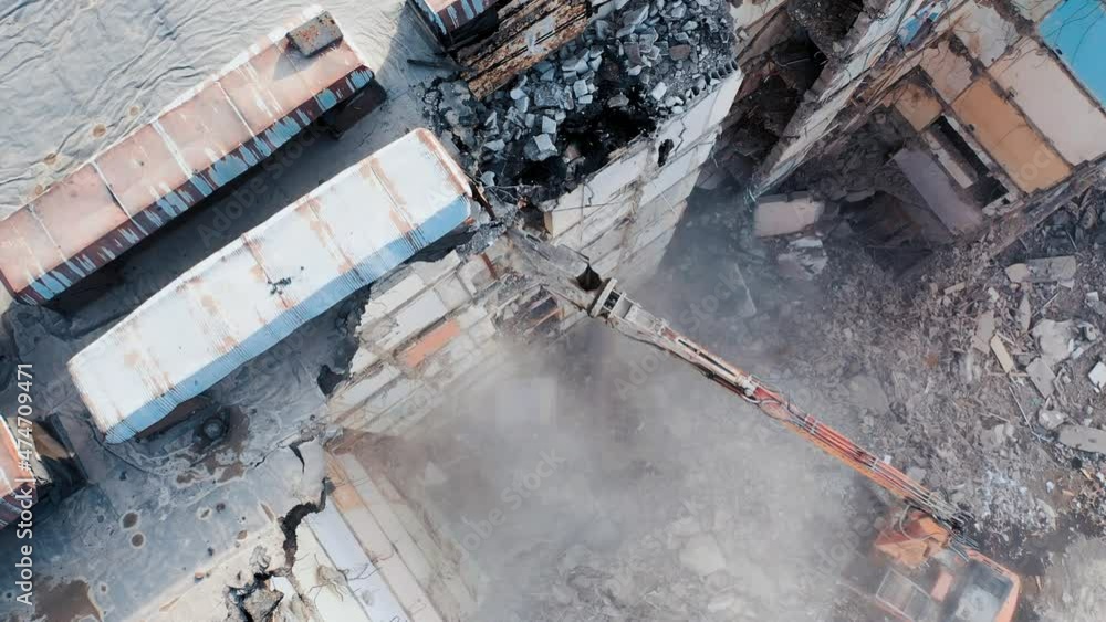 Dismantling of concrete structures with an excavator. Demolition of a multi-story building, for future development of residential buildings