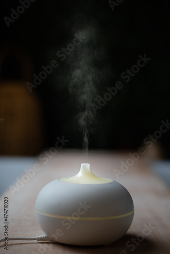 essential oil diffuser. electric aromatherapy device. steam against black background