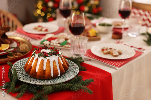 Festive dinner with delicious cake served on table indoors  space for text. Christmas Eve celebration