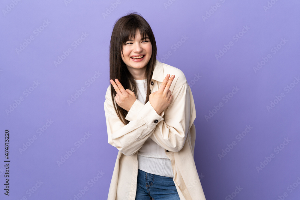 Young Ukrainian woman isolated on purple background smiling and showing victory sign Young Ukrainian woman isolated on purple background smiling and showing victory sign