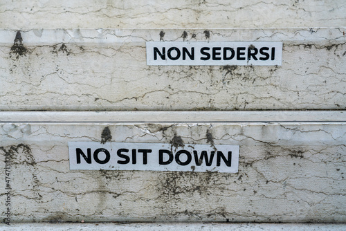 Funny translation on warning labels in Venice forbidding tourists to sit down © Robert Ray