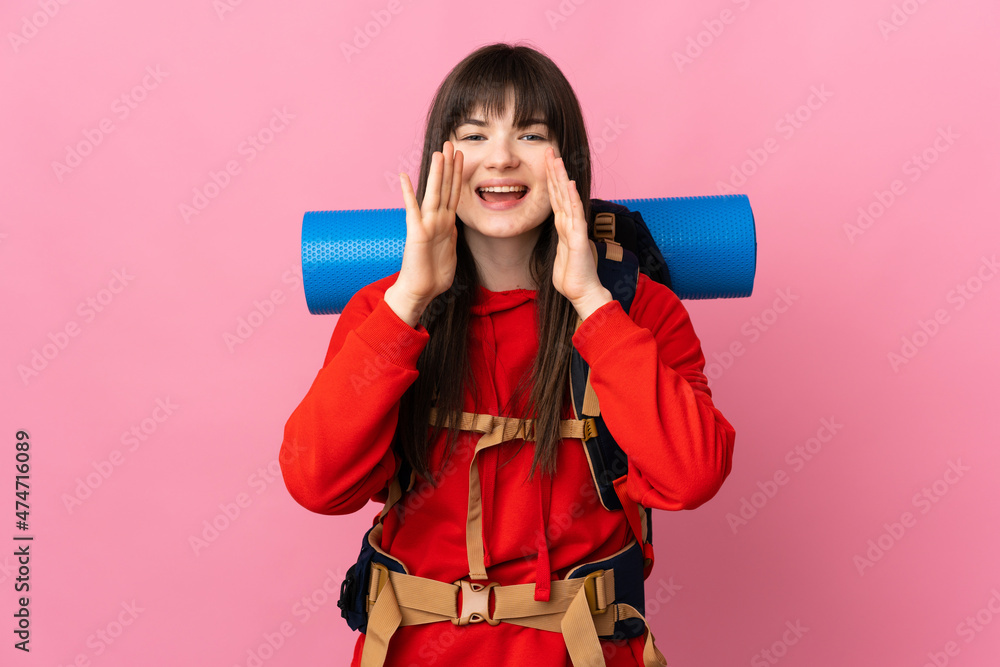 Mountaineer Ukrainian girl with a big backpack isolated on pink background shouting with mouth wide open Mountaineer Ukrainian girl with a big backpack isolated on pink background shouting with mouth wide open