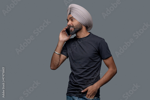 Joyous attractive Indian man having a phone conversation