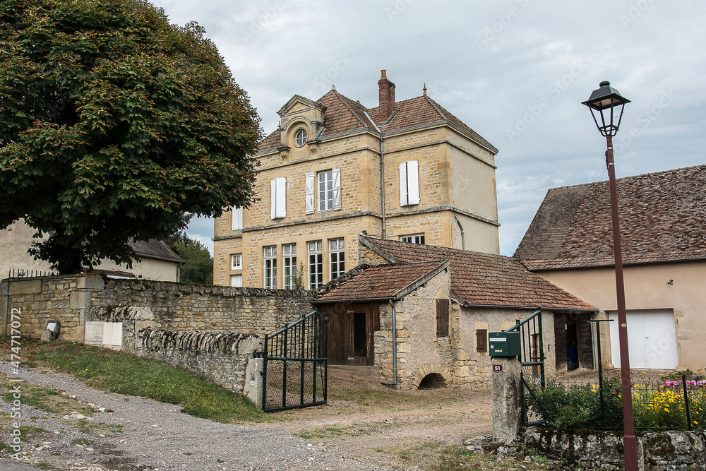 former school with walled schoolyard and chestnut tree and houses in the little Brionnais village of Vareilles