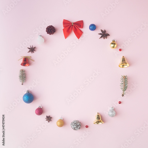A circle made of Christmas decorations on a pink background. Minimal Christmas composition.