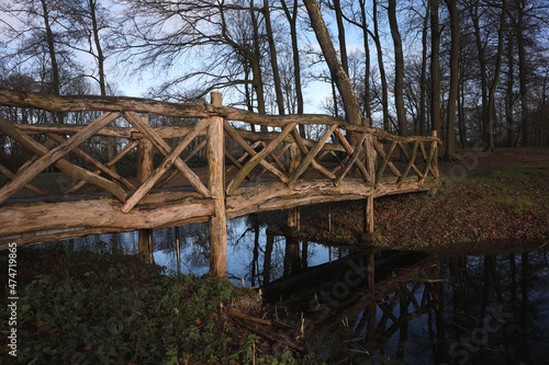 A local park with a wooden bridge over water
 photo