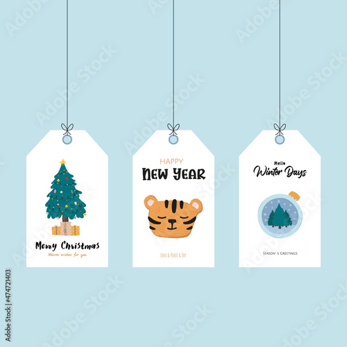 Greeting printable tags with doodle christmas balls, Christmas tree and tiger for gifts and wishes. Festive hand drawing elements orange, green and blue colors on sky blue background.