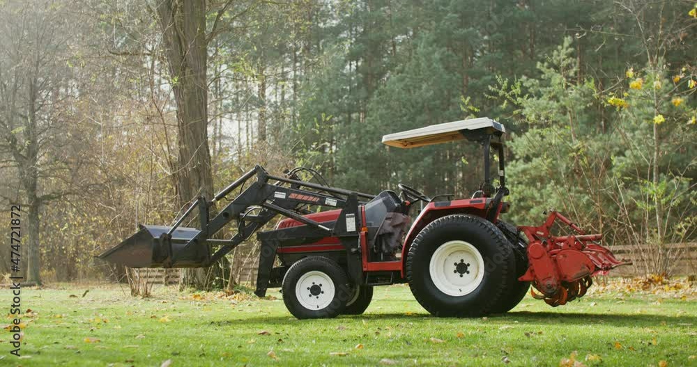 A modern agricultural tractor stands on a farm on an autumn sunny day A modern agricultural tractor stands on a farm on an autumn sunny day