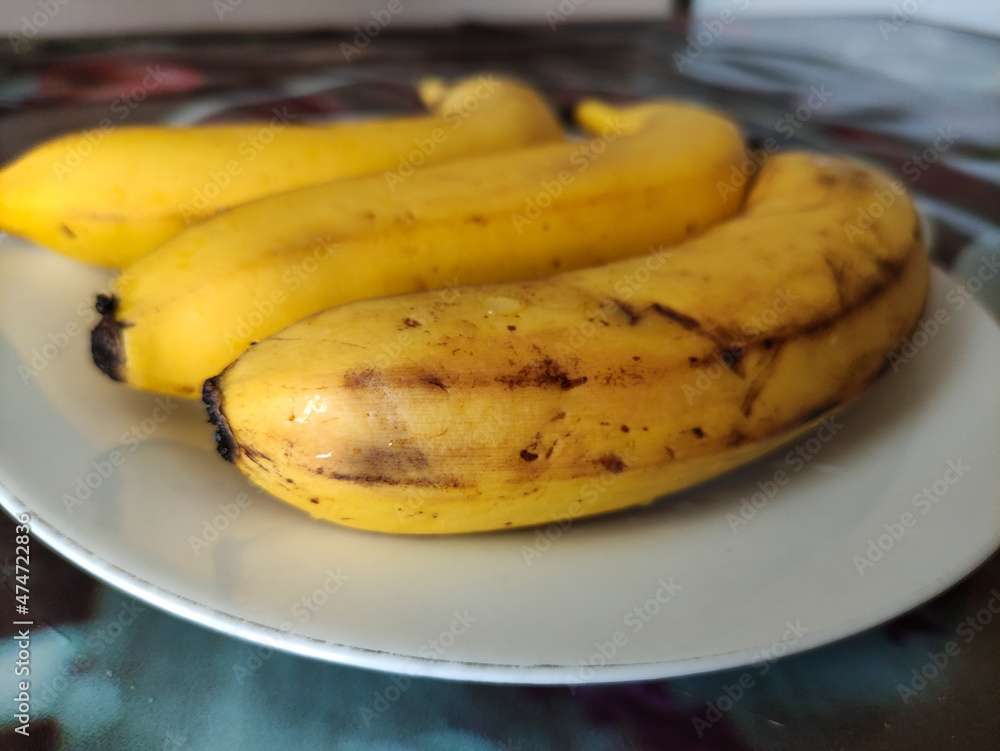 Overripe bananas with dark marks on a plate Overripe bananas with dark marks on a plate
