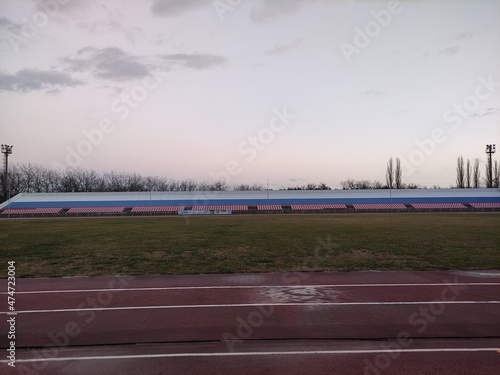 Running tracks and tribunes in the stadium in evening in winter © Alex Milan