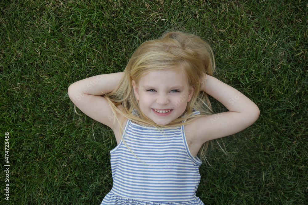 Portrait of cute little girl laying on the grass Portrait of cute little girl laying on the grass