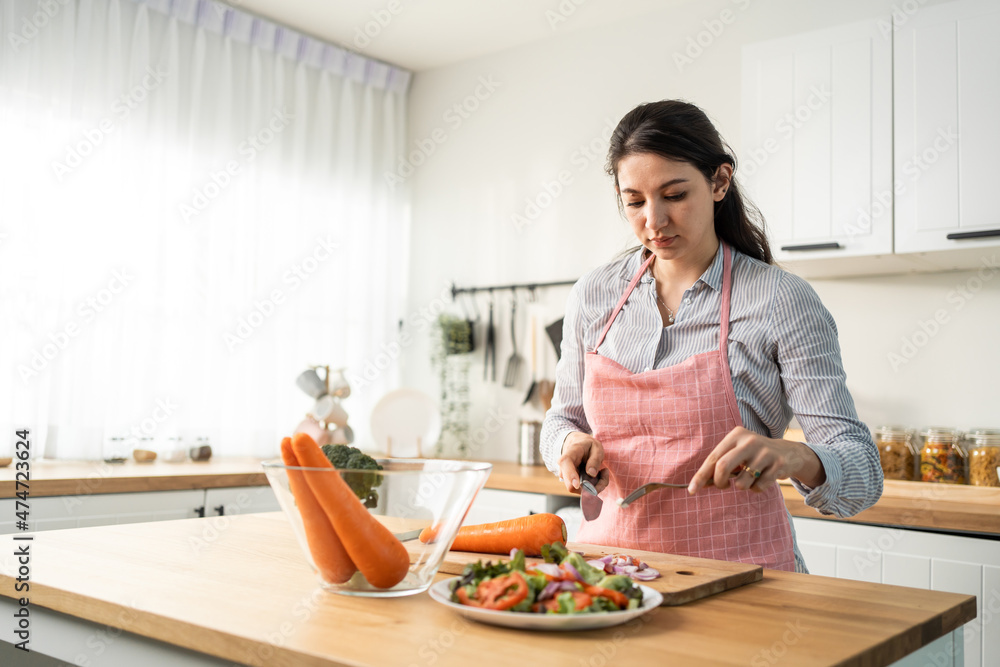 Caucasian loving woman wear apron cook green salad in kitchen at home. Caucasian loving woman wear apron cook green salad in kitchen at home.
