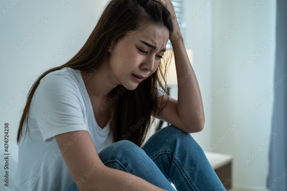 Asian beautiful depression girl crying in tears sit on bed in bedroom. Asian beautiful depression girl crying in tears sit on bed in bedroom.