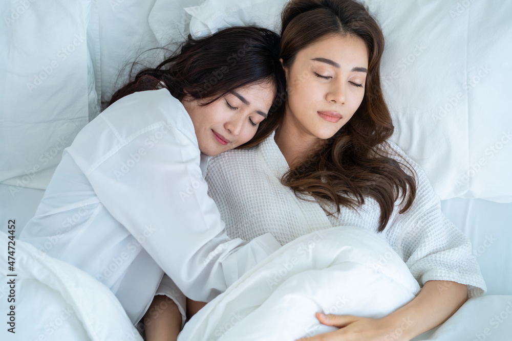 Asian beautiful lesbian couple lying down on bed in bedroom at home. Asian beautiful lesbian couple lying down on bed in bedroom at home.