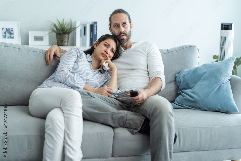 Caucasian loving couple watch movie together in living room at home. Caucasian loving couple watch movie together in living room at home.