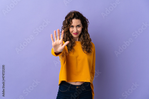 Young caucasian woman isolated on purple background counting five with fingers