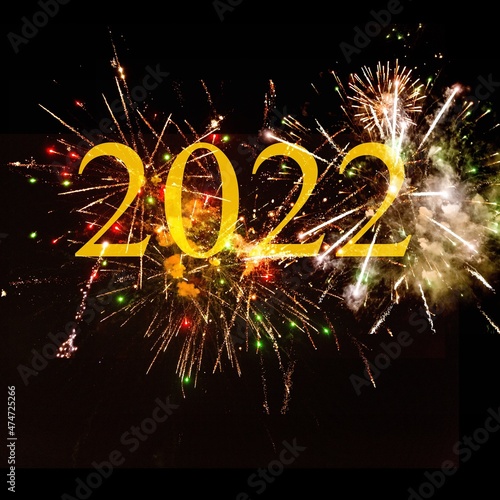 Happy New Year 2022. Sparkling burning numbers with firework on black background.