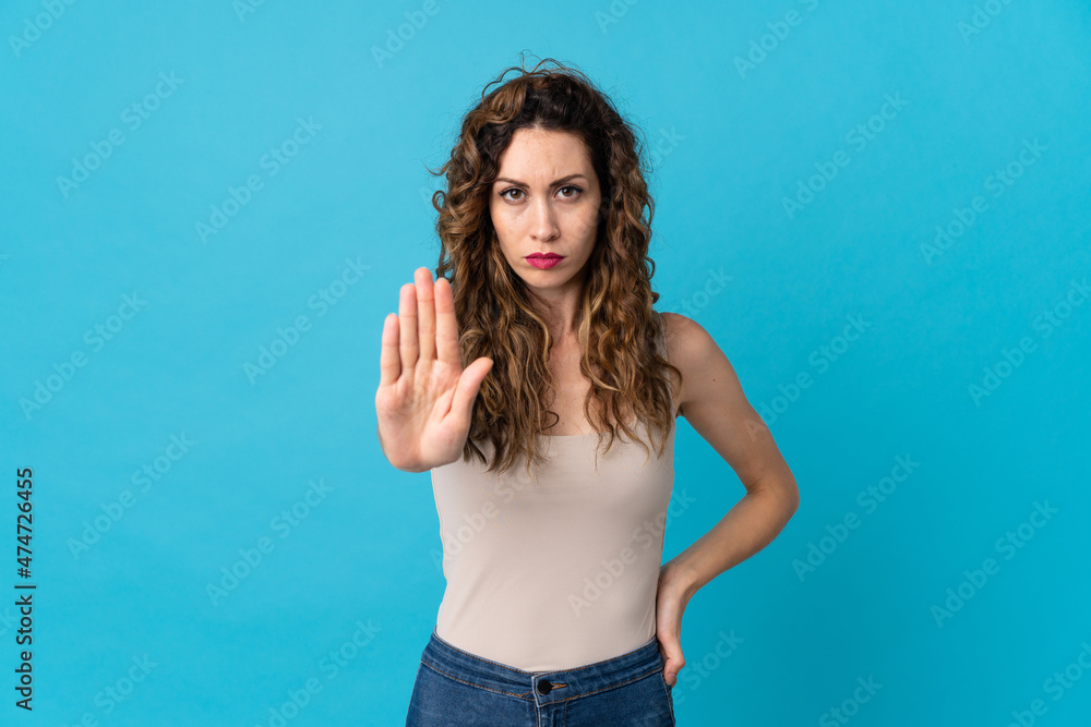 Young caucasian woman isolated on blue background making stop gesture Young caucasian woman isolated on blue background making stop gesture