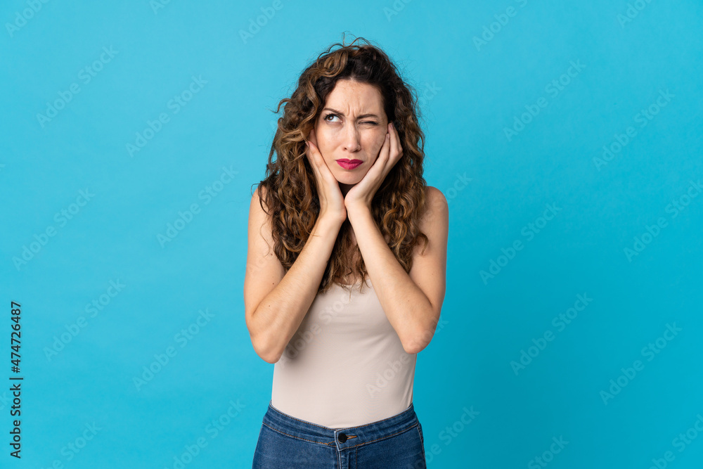 Young caucasian woman isolated on blue background frustrated and covering ears Young caucasian woman isolated on blue background frustrated and covering ears
