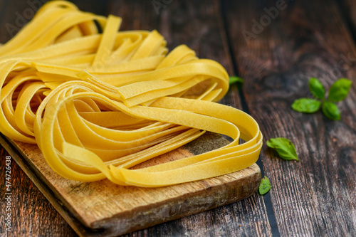 Raw fresh uncooked tagliatelle egg pasta . Ready for cooking. Italian food concept. Kitchen poster