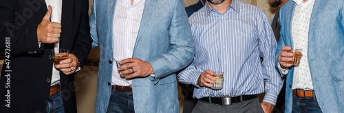 man holding a drink at a party business jacket 