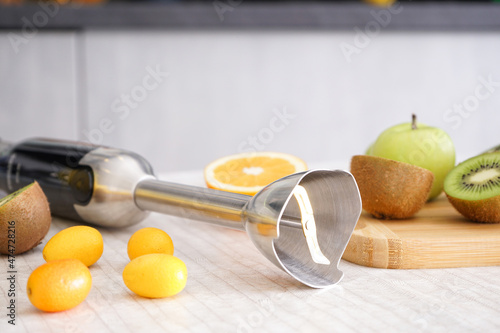 Foto Home kitchen with ripe fruit table and hand blender, closeup.