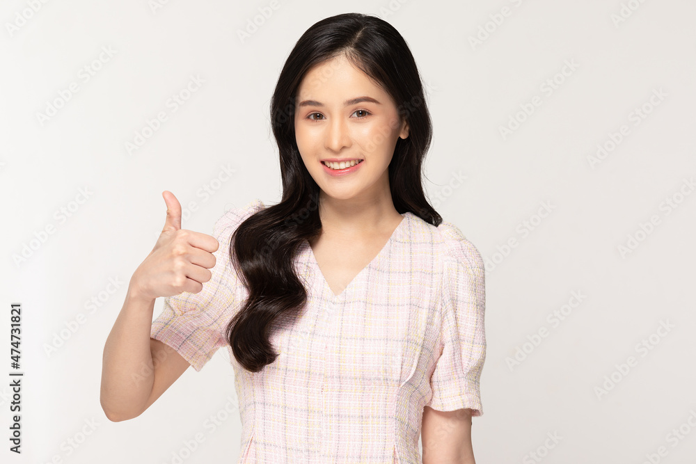 Happy attractive asian young woman smile showing thumbs up with copy space isolated on white background.Cheerful pretty girl wear casual dress showing good sign.Positive Expression Happy attractive asian young woman smile showing thumbs up with copy space isolated on white background.Cheerful pretty girl wear casual dress showing good sign.Positive Expression