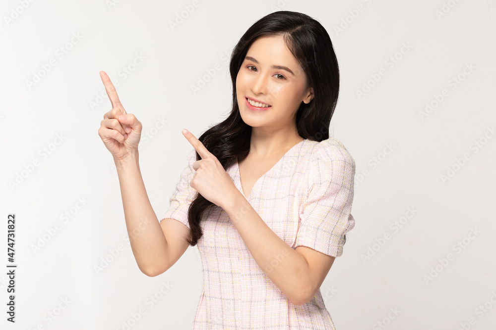 Happy attractive asian young woman smile and pointing to copy space isolated on white background.Cheerful pretty girl wear casual dress pointing finger to empty space for mockup to display product Happy attractive asian young woman smile and pointing to copy space isolated on white background.Cheerful pretty girl wear casual dress pointing finger to empty space for mockup to display product