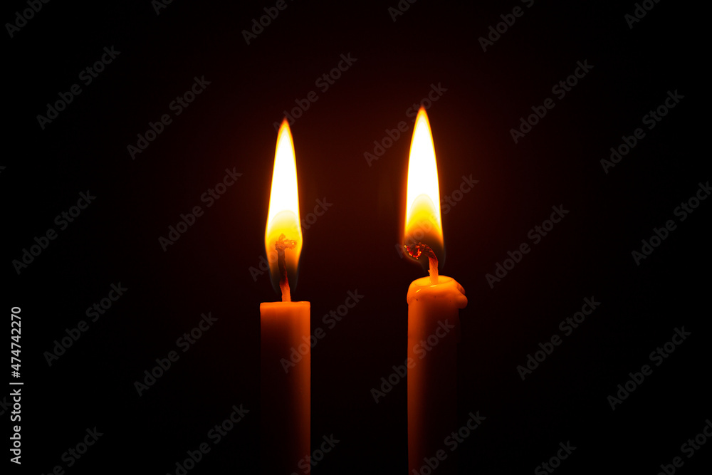 Two big burning candles. Bright light on dark background. RIP darkness template. Birthday party. Romantic evening on Valentine Two big burning candles. Bright light on dark background. RIP darkness template. Birthday party. Romantic evening on Valentine