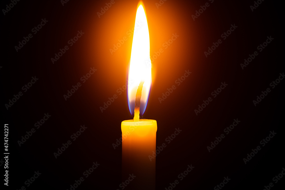 Close up single candle light and flame on black background Close up single candle light and flame on black background