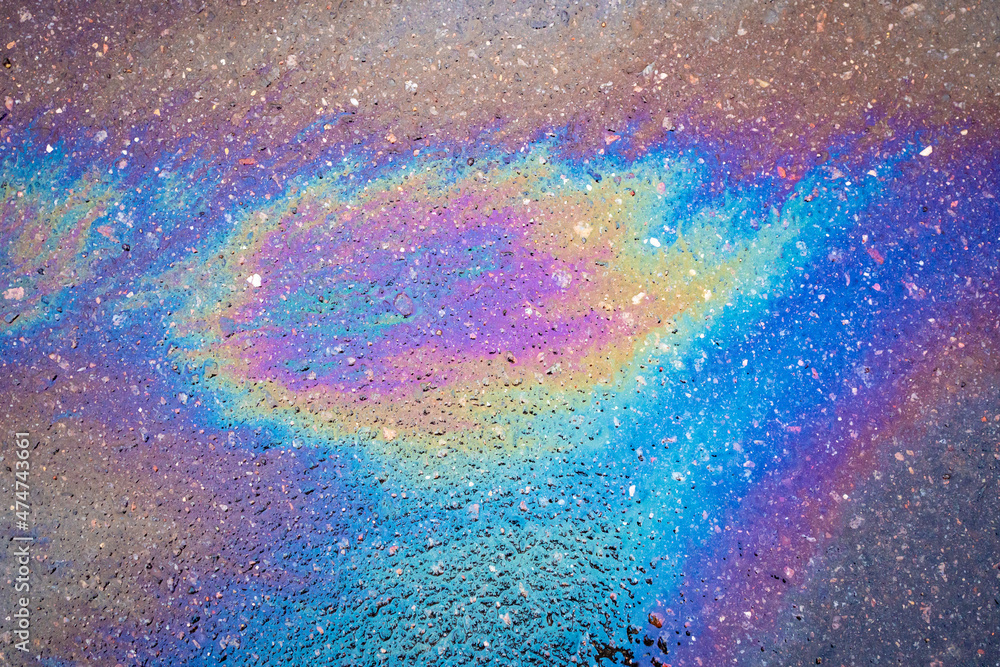 Beautiful abstract stain of motor oil, gas or petrol spilled on the asphalt