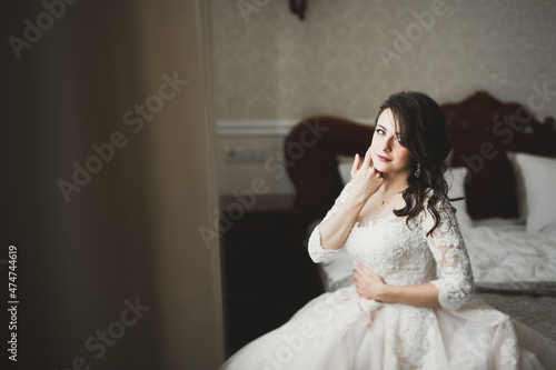 Beautiful bride wearing fashion wedding dress with feathers with luxury delight make-up and hairstyle, studio indoor photo shoot © olegparylyak