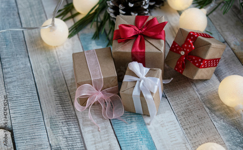 Gift wrapping, Christmas decor and a garland of glowing lights on a wooden table. Festive concept. Gifts for Christmas and New Year.