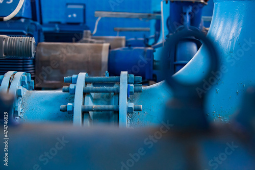 Tubes of water treatment station. Pumping equipment, machine room. Close up photo. Part on foreground blurred. Abstract industrial backdrop.