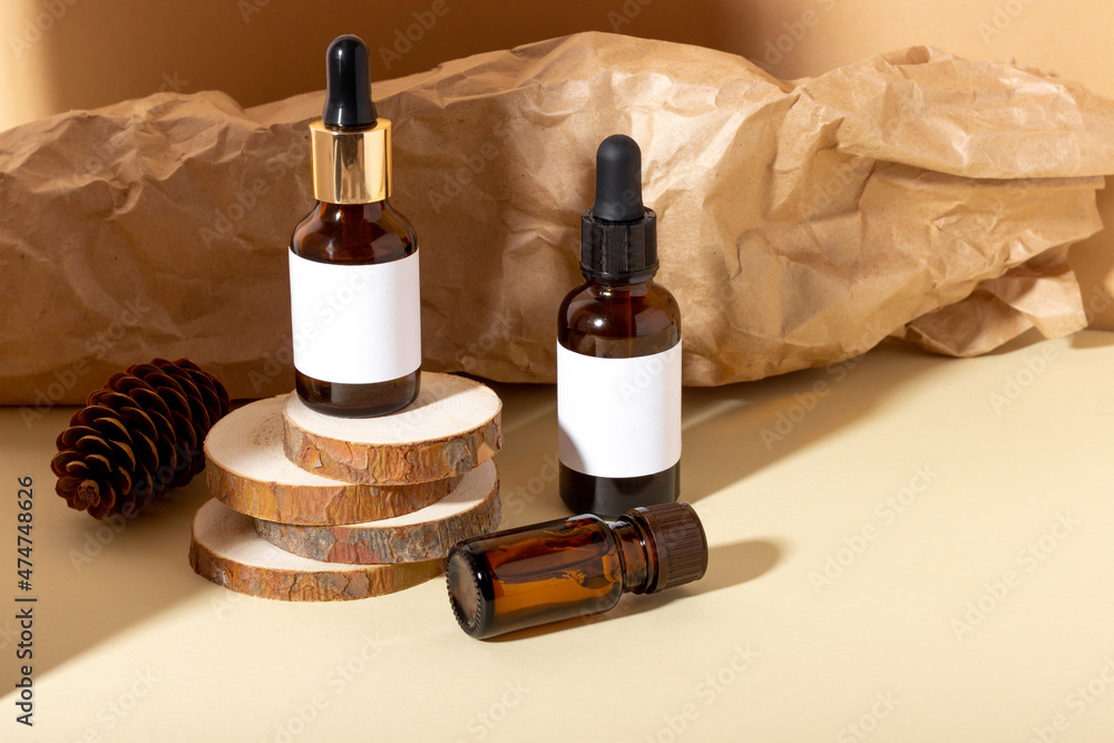 Cosmetic jar with cream, serum or organic essential oil for the face and body, against the background of a log and hard shadows. The concept of a beauty salon and natural cosmetics. Cosmetic jar with cream, serum or organic essential oil for the face and body, against the background of a log and hard shadows. The concept of a beauty salon and natural cosmetics.