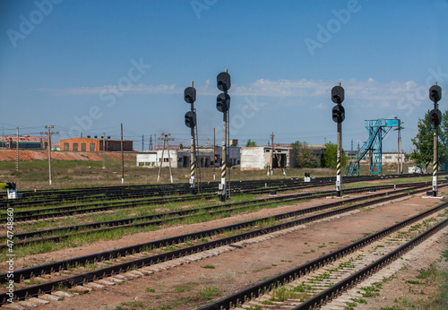 Old Soviet railway station in industrial zone. Traffic lights, industrial buildings, electric poles. Blue sky. photo