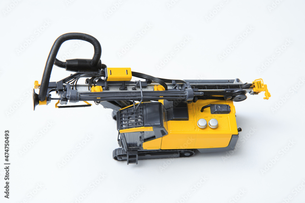Drilling machine for contour drilling of boreholes for blast preparation in the quarry. The layout of a small quarry drilling rig on a white background. Drilling machine for contour drilling of boreholes for blast preparation in the quarry. The layout of a small quarry drilling rig on a white background.