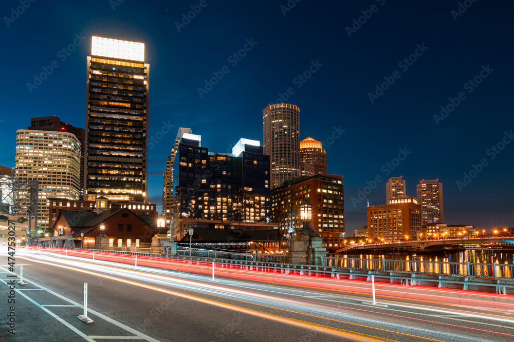 Panoramic picturesque city view of Boston Harbour and Seaport Blvd at night time, Massachusetts. An intellectual, technological and political center. Building exteriors of financial downtown.