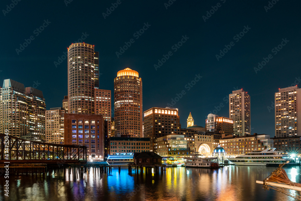 Panoramic city view of Boston Harbour and Seaport Blvd at night time, Massachusetts. An intellectual, technological and political center. Building exteriors of financial downtown.